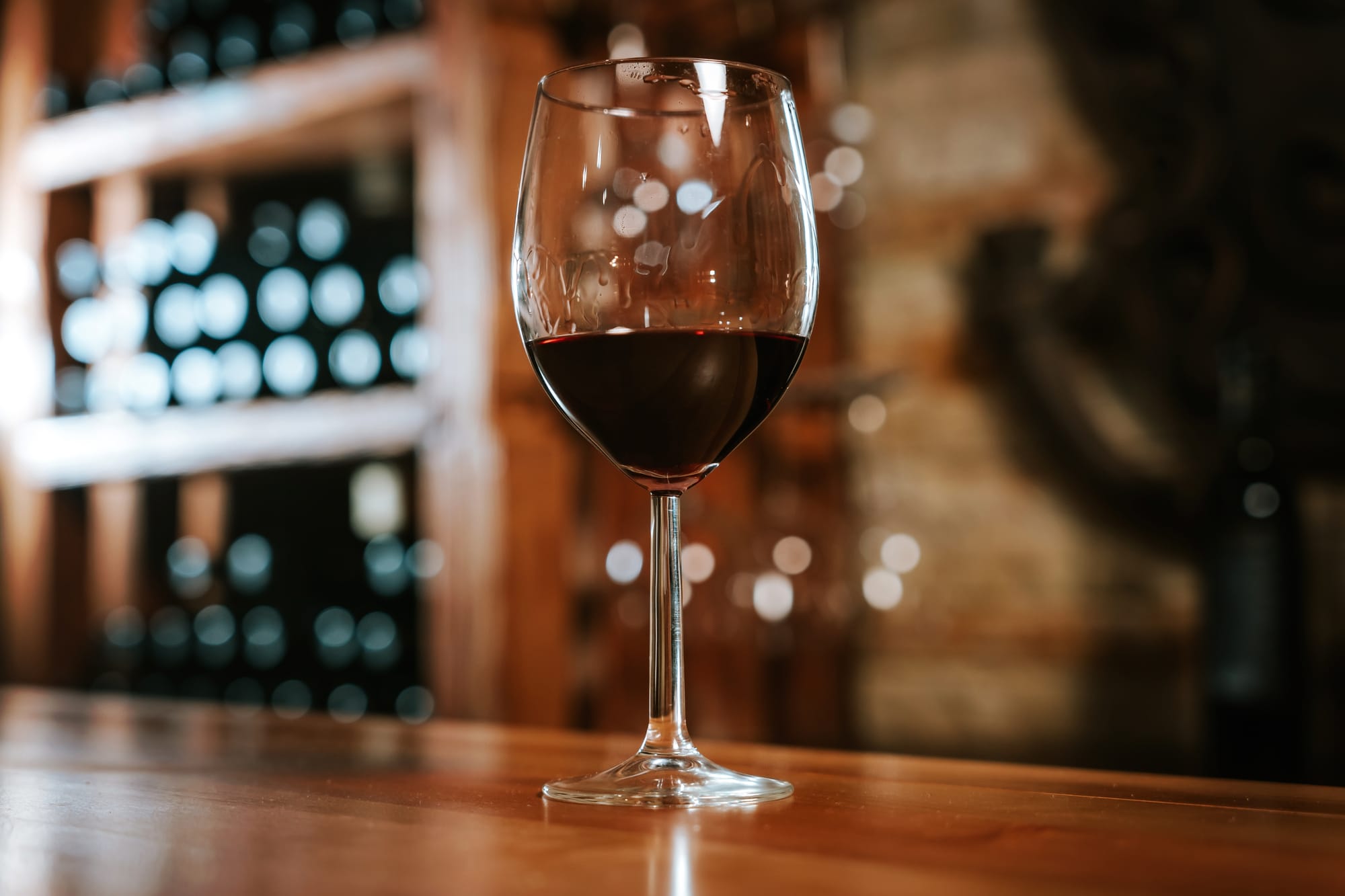 Glass of Red Wine on Wooden Table in Cellar