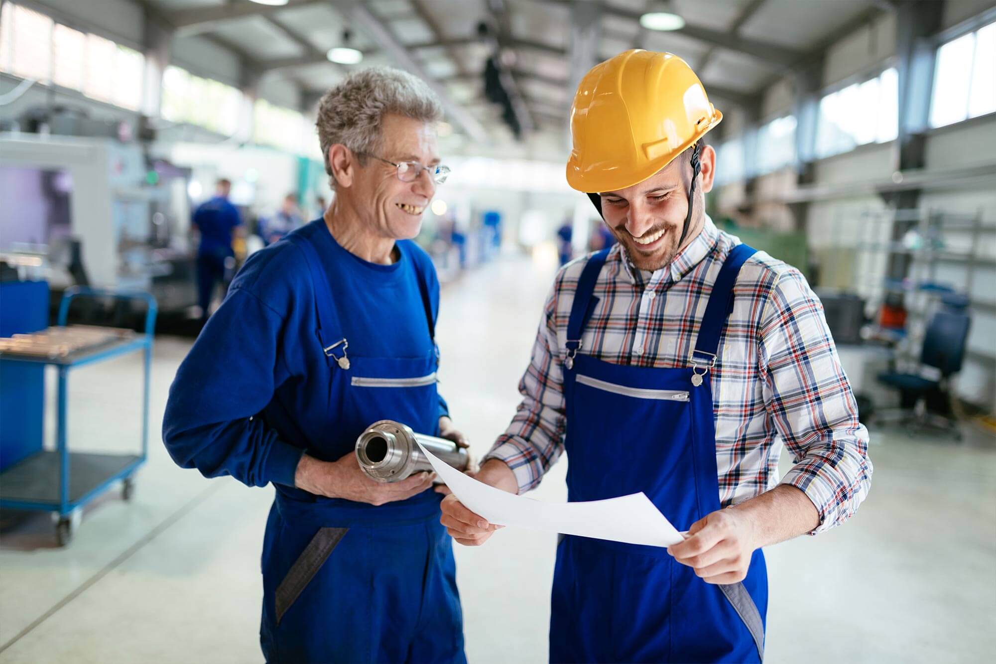 two manufacturing workers looking at paper
