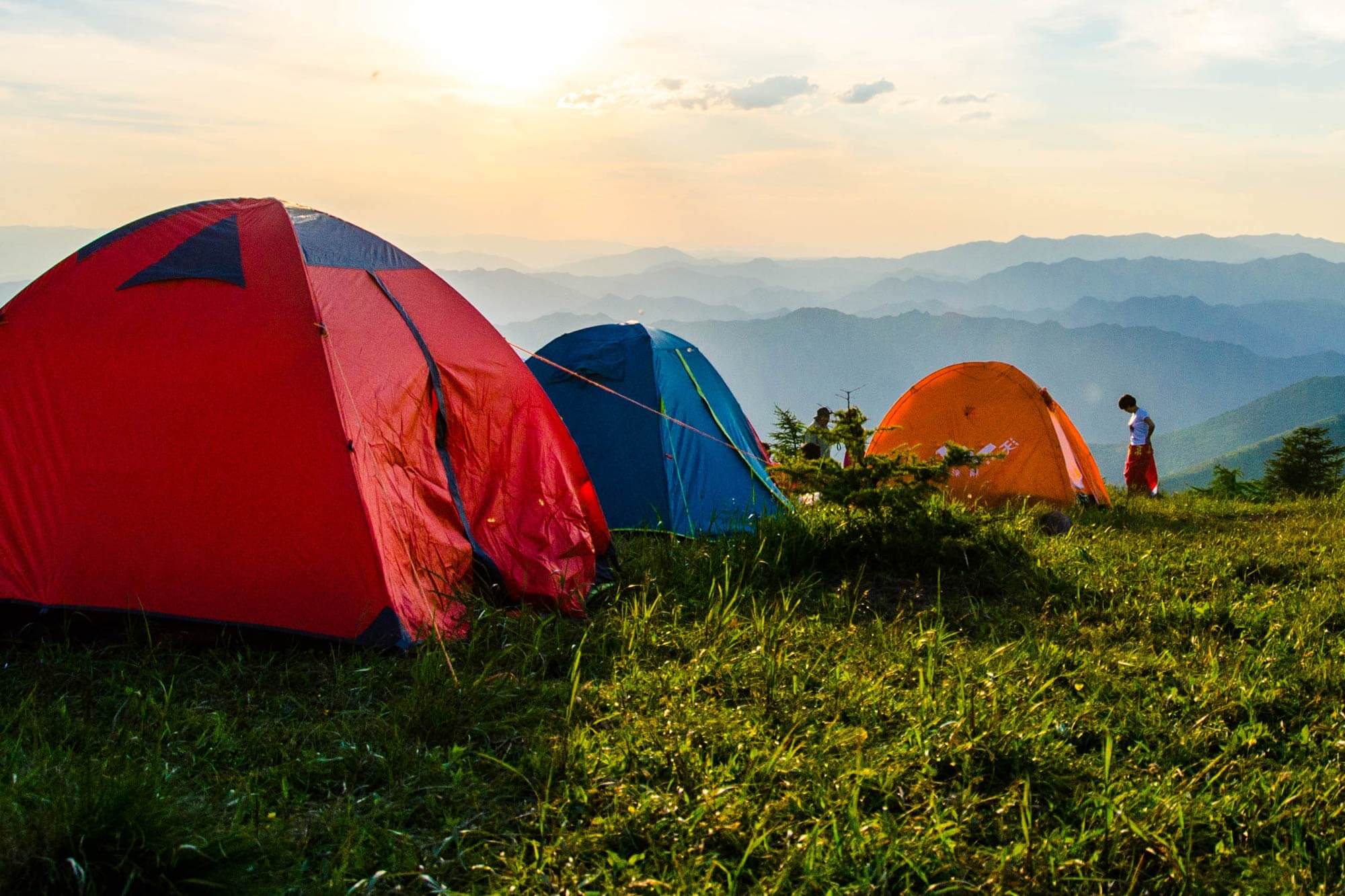 three tents by a mountain